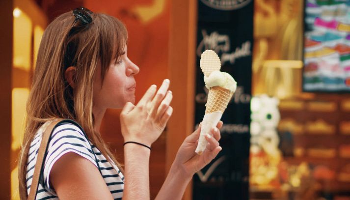 Donna mangia gelato fuori dalla gelateria