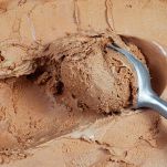 Cucchiaio immerso nel gelato al cioccolato
