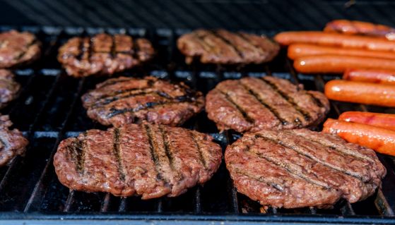 Cottura sulla griglia di hamburger e wurstel