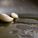 Spicchi d'aglio che soffriggono in padella