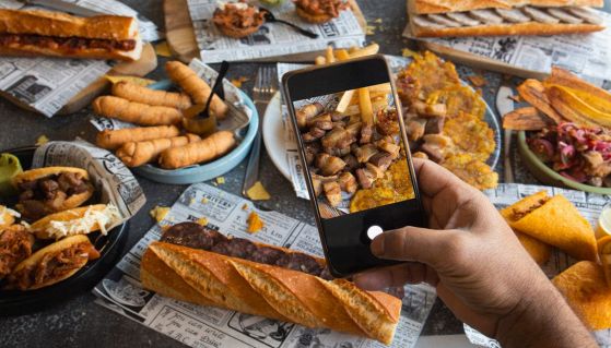 Mani tengono lo smartphone per fotografare cibo