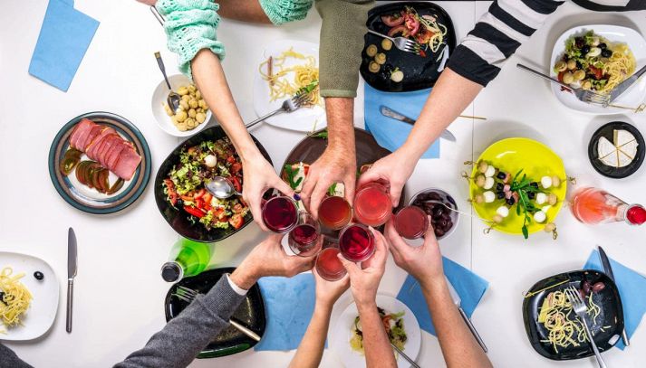 Tavolo di amici che mangiano e brindano