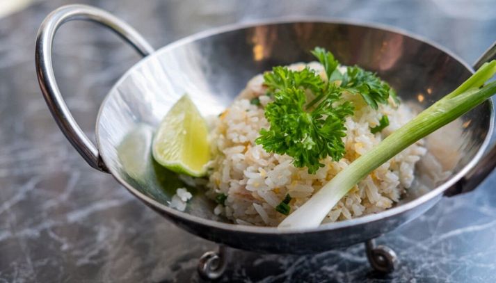 Vassoio d'acciaio con riso al cocco con prezzemolo e lime