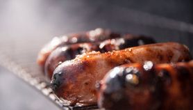 Capi di salsiccia di suino che cuociono su una griglia al sole