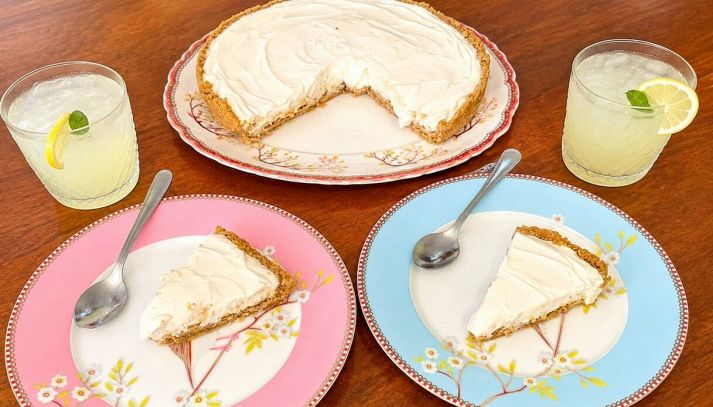 Torta fredda al limone con due porzioni impiattate e limonata
