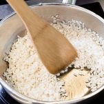 Riso tostato in padella con il cucchiaio di legno