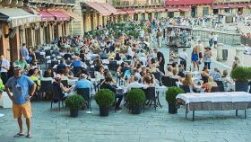 Turisti stranieri affollano i tavolini di bar e ristoranti in Piazza del Campo, Siena