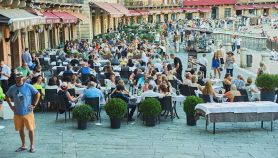 Turisti stranieri affollano i tavolini di bar e ristoranti in Piazza del Campo, Siena
