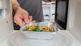 Cibo già pronto messo nel microonde da un uomo