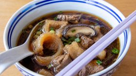 Una ciotola di zuppa di tartaruga con bacchette