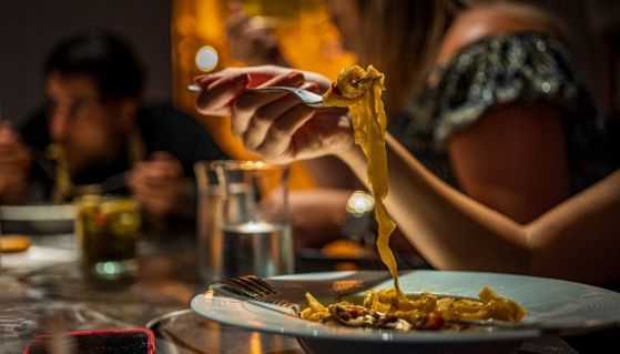 Degli americani mangiano pasta a cena in un ristorante di lusso
