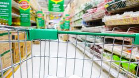 Supermercato con carrello della spesa in primo piano