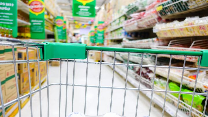Supermercato con carrello della spesa in primo piano