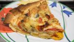 Piatto con fetta di crostata salata con i peperoni