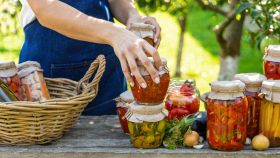 Giardino con donna che sistema le conserve