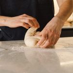 Donna lavora l'impasto facendo le pieghe