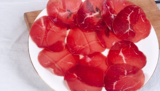 Fette di bresaola in piatto e su un tagliere