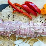 Maiale crudo arrotolato con fette di pancetta