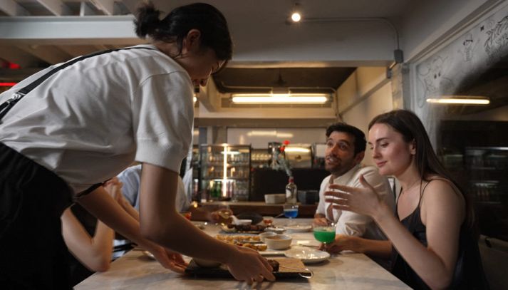 Cameriera serve tavolo di amici al ristorante