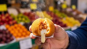 Arancino fumante da cui fuoriesce la mozzarella