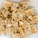 Cubetti di mollica di pane bagnati con latte al timo
