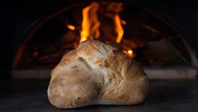 Pagnotta di pane di Altamura con forno a legna sullo sfondo