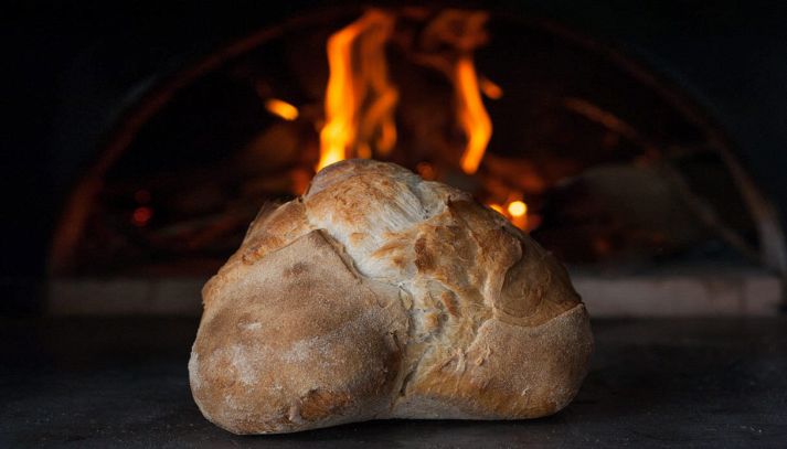 Pagnotta di pane di Altamura con forno a legna sullo sfondo