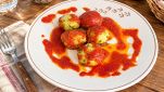 Polpette di pane e piselli con il sugo nel piatto