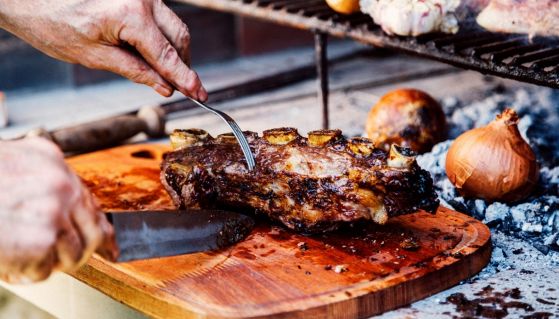 Un argentino taglia un roast beef cotto con tecnica asado