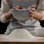 Spianatoia con donna che setaccia la farina