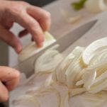 Mani affettano i finocchi sul tagliere