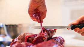 Un macellaio dimostra la sua perizia col taglio della carne