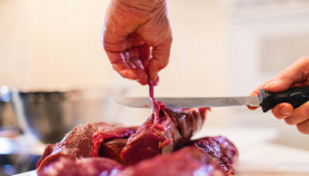 Un macellaio dimostra la sua perizia col taglio della carne