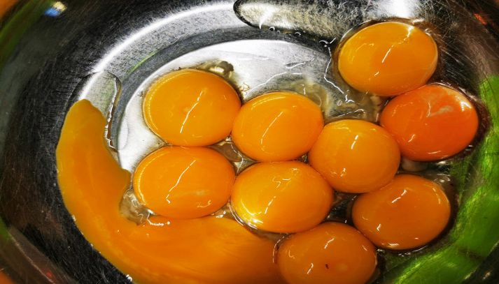 Uova fresche aperte nella ciotola