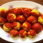 Polpette di pane e piselli al sugo su sfondo di legno