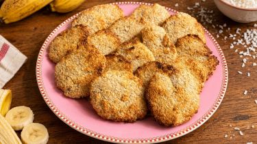 Biscotti nel piatto con banane e cocco in scaglie sul tavolo