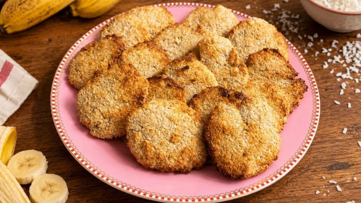 Biscotti nel piatto con banane e cocco in scaglie sul tavolo