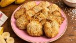 Biscotti nel piatto con banane e cocco in scaglie sul tavolo