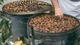 Castagne cotte su una grande griglia circolare da un ambulante