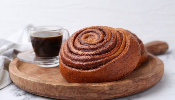Cinnamon roll svedesi accanto ad una tazza di caffè espresso