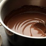 Ganache al cioccolato nella ciotola con il cucchiaio di legno