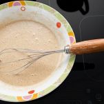 Ciotola con impasto dei pancake e frusta manuale