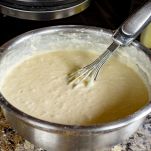 Impasto della torta nella ciotola con la frusta manuale