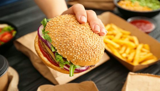 Hamburger del fast food tenuto da mano femminile