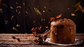 Panettone ad ottobre su un tavolo in legno con foglie secche che cadono