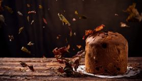 Panettone ad ottobre su un tavolo in legno con foglie secche che cadono