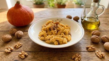 Tavolo con piatto di pasta con pesto di zucca