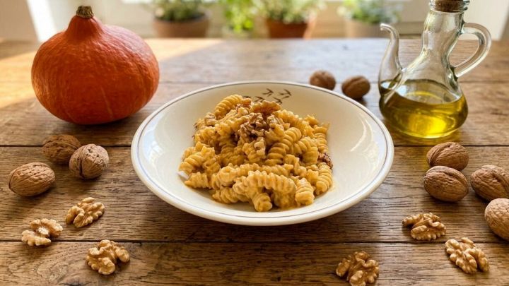 Tavolo con piatto di pasta con pesto di zucca