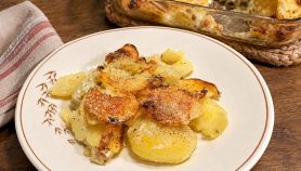 Patate cremose nel piatto con teglia sullo sfondo