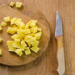 Patate crude tagliate a cubetti sul tagliere